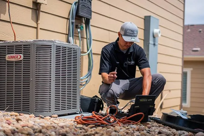 HVAC technician diagnosing an outdoor residential air conditioning system