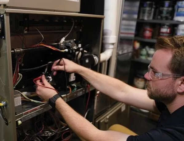 HVAC technician repairing internal heating equipment components